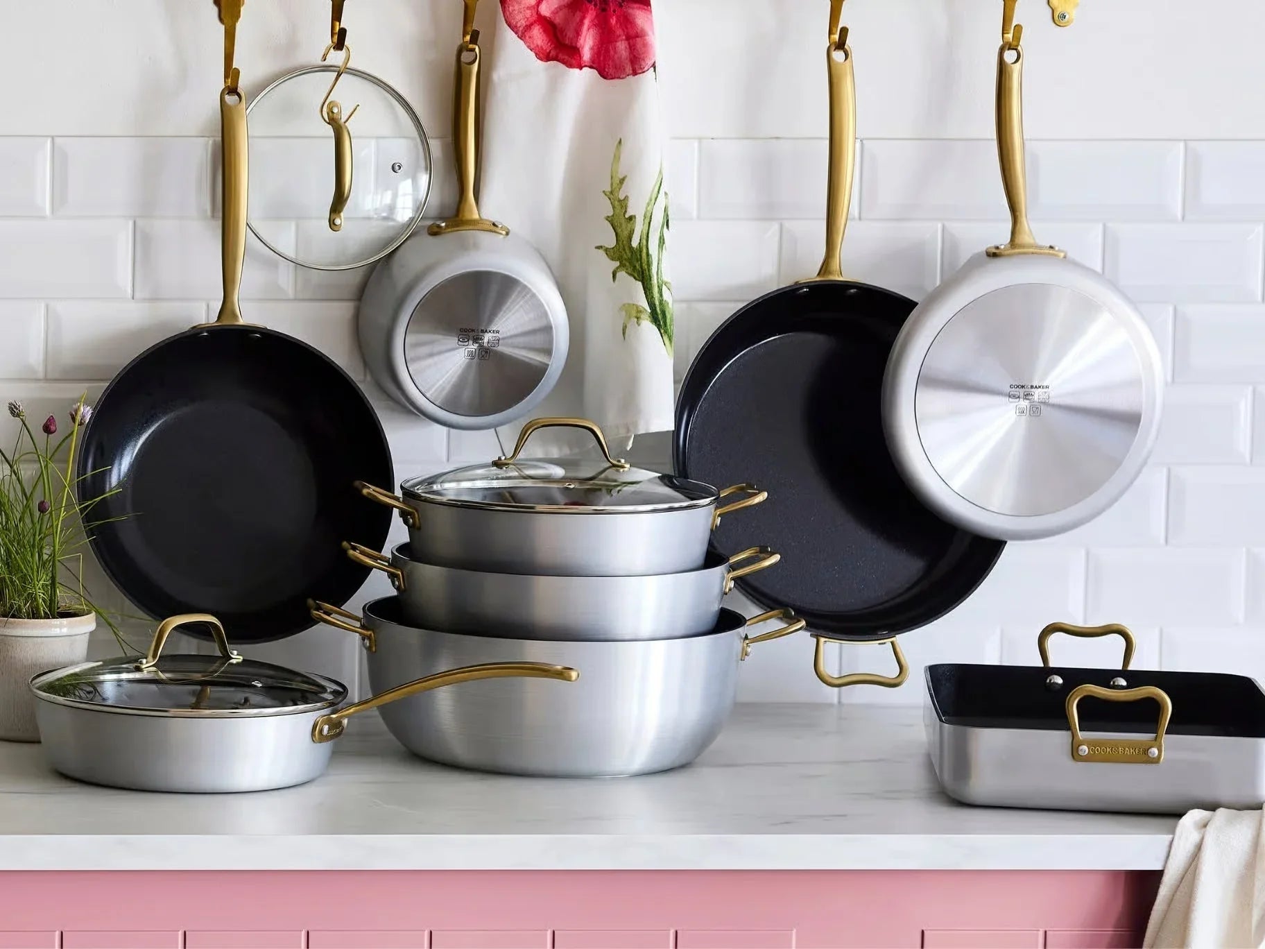 Nordic Cookware kastruller och stekpannor med gulddetaljer på köksbänk