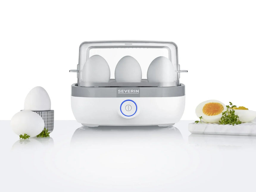 Severin äggkokare med tre ägg, kokta ägg och örter på ett vitt kök, Nordic Cookware