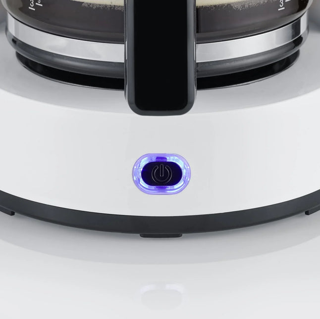 Närbild på bryggare i vitt med lysande strömknapp, Nordic Cookware köksutrustning.