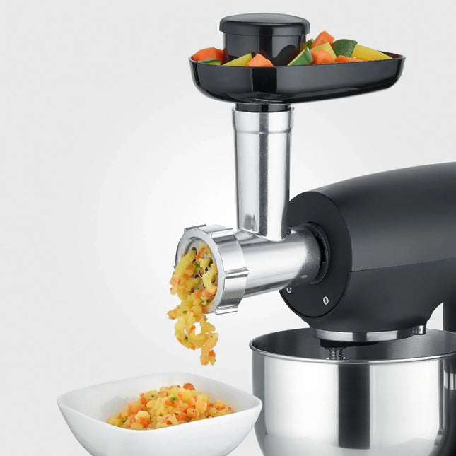 Matberedare från Nordic Cookware maler grönsaker i rostfri skål och vit skål