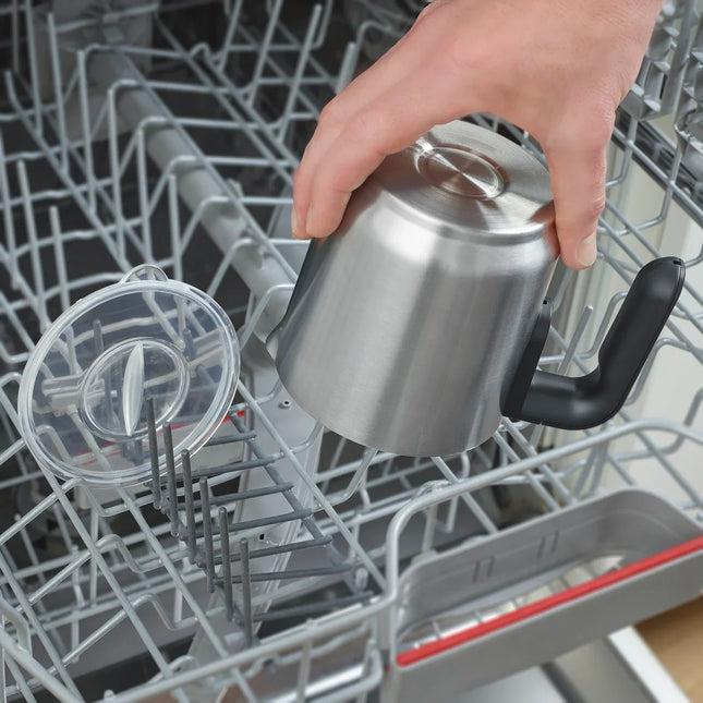 Hand placerar rostfri kastrull från Nordic Cookware i diskmaskin, lock bredvid